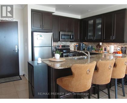 A kitchen with a refrigerator, microwave, oven, and sink.