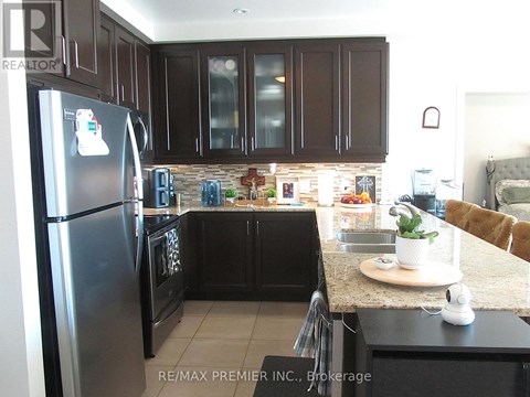 A kitchen with a refrigerator and a stove top oven.