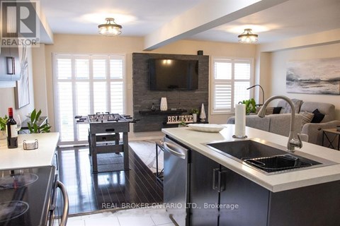 A modern kitchen with a dining table and a flat screen TV mounted on the wall.