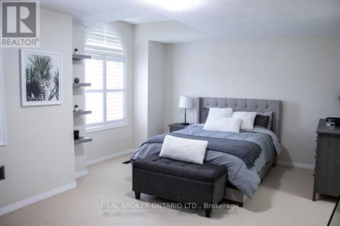 A bedroom with a large bed and a nightstand.