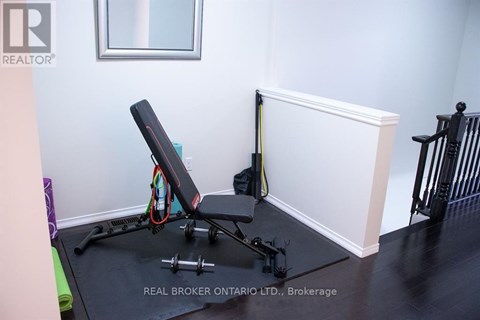 A gym setup in a room with a mirror, a bench, and a resistance band.