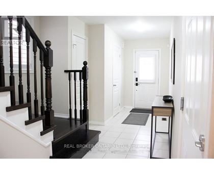 A hallway with a black staircase and white walls.