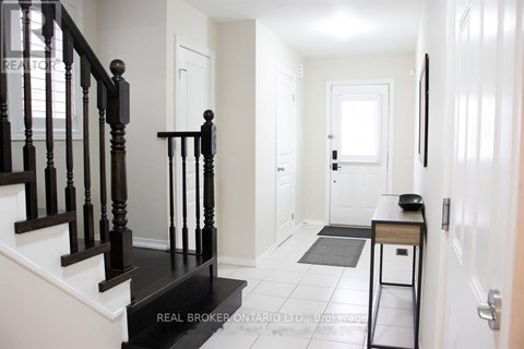 A hallway with a black staircase and white walls.