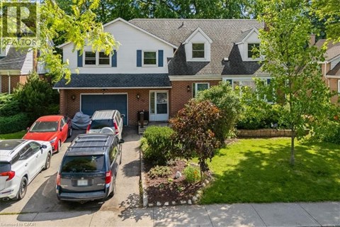 A house with a garage and a tree in front.
