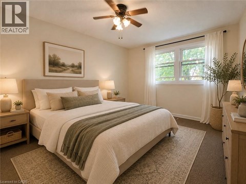 A bedroom with a large bed and a ceiling fan.