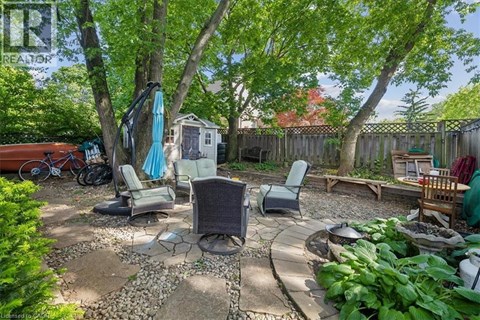 A backyard with a table and chairs under trees.