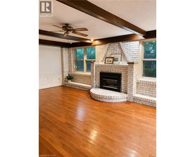 A living room with a fireplace and a ceiling fan.