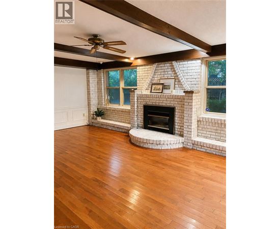 A living room with a fireplace and a ceiling fan.
