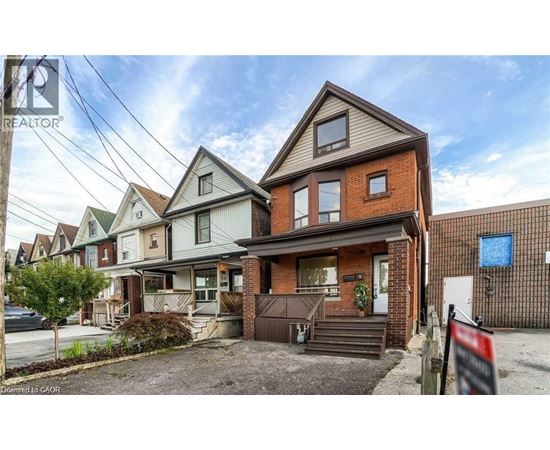 A house with a brown roof and a sign that says "REALTOR" in front of it.
