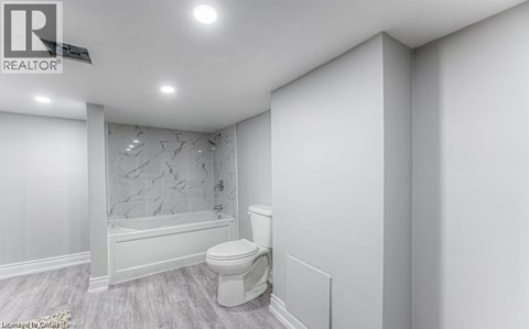 A white bathroom with a toilet and a bathtub.