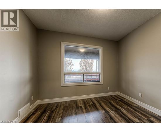 A room with a window and wooden floors.