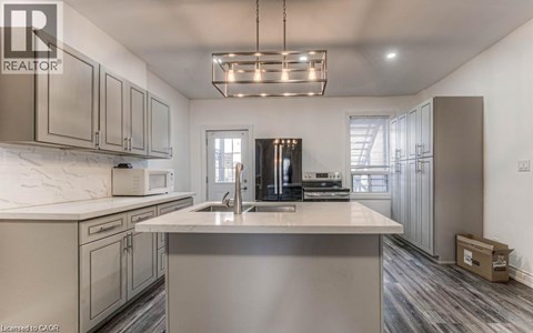 A modern kitchen with a large island and stainless steel appliances.