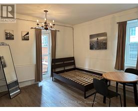 A room with a bed, a table and chairs.
