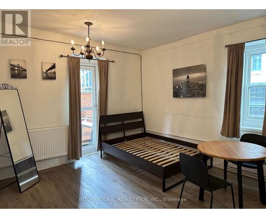 A room with a bed, a table and chairs.
