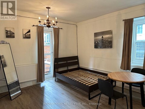A room with a bed, a table and chairs.