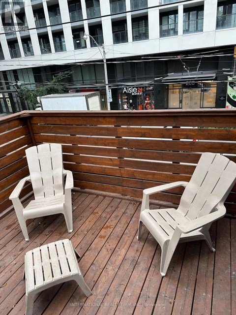 Two chairs and a small table are on a wooden deck.