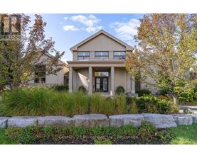 A beige house with a stone wall in front.