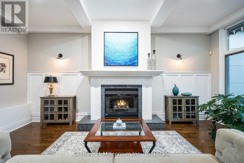 A living room with a fireplace and a painting on the wall.