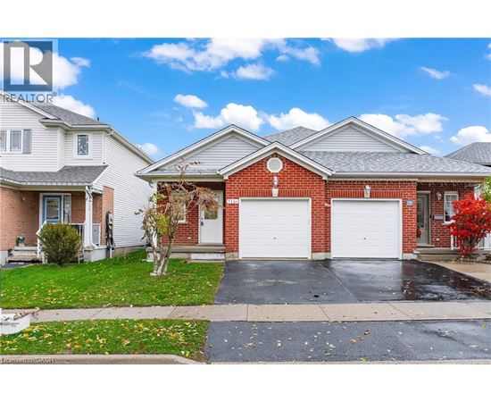 A red brick house with a white garage door is for sale.