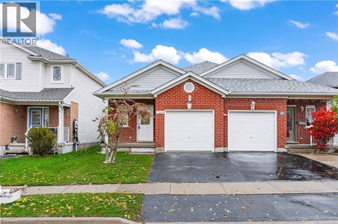 A red brick house with a white garage door is for sale.