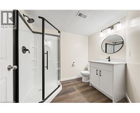 A bathroom with a toilet, sink, and shower.