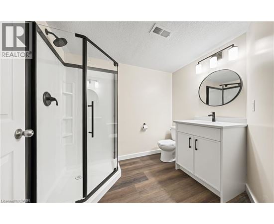 A bathroom with a toilet, sink, and shower.
