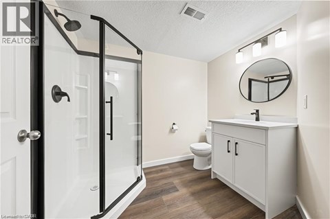 A bathroom with a toilet, sink, and shower.