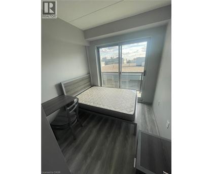 A bedroom with a bed, desk, and chair.