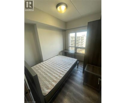 A bedroom with a large bed and a window overlooking a balcony.