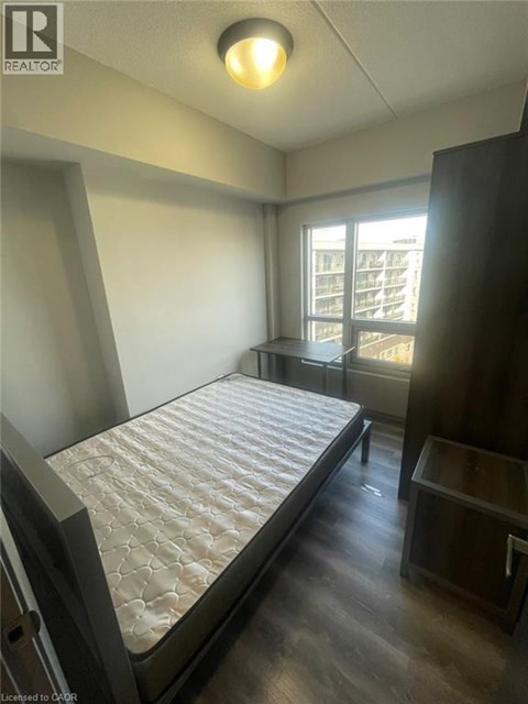 A bedroom with a large bed and a window overlooking a balcony.