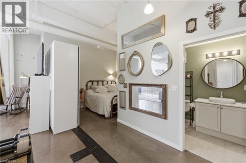 A bedroom with a large bed and a vanity with a mirror.