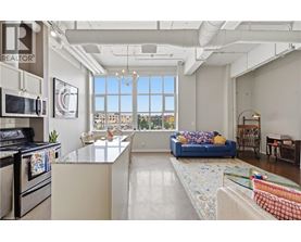A well-lit kitchen with a view of the cityscape outside the window.