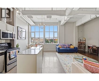 A well-lit kitchen with a view of the cityscape outside the window.