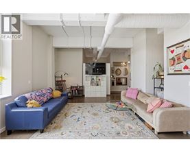 A living room with a blue couch and a rug.