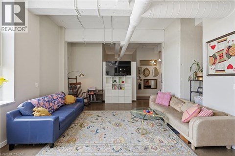 A living room with a blue couch and a rug.