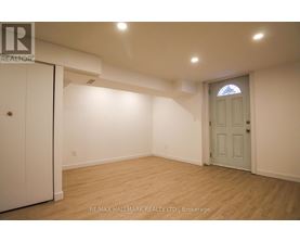 A room with a white door and a window with a stained glass design.