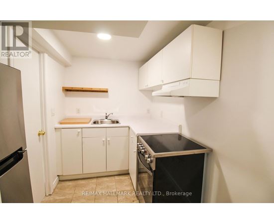 A small kitchen with a black oven and white cabinets.
