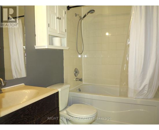 A bathroom with a toilet, sink, and bathtub.
