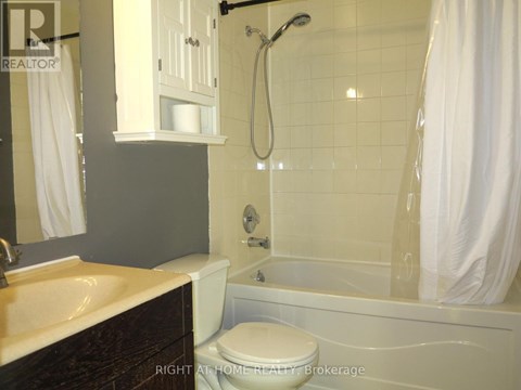 A bathroom with a toilet, sink, and bathtub.