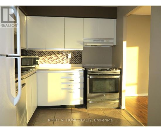 A kitchen with white cabinets and a stainless steel oven.