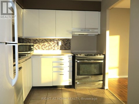 A kitchen with white cabinets and a stainless steel oven.