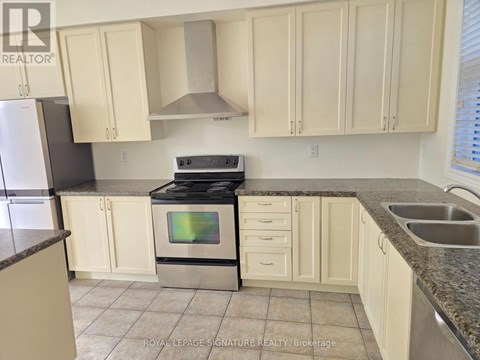 A kitchen with white cabinets and a black stove top oven.