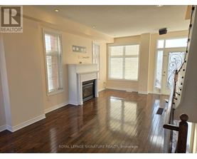 A spacious living room with wood flooring and a fireplace.