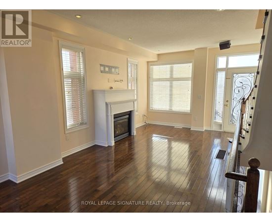 A spacious living room with wood flooring and a fireplace.