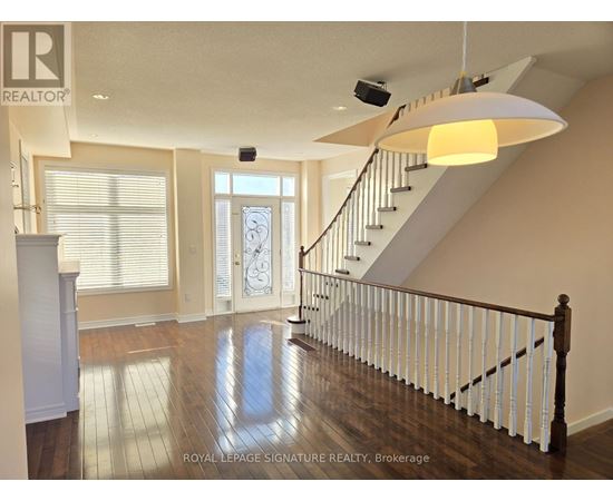 A spacious room with a staircase and a chandelier.