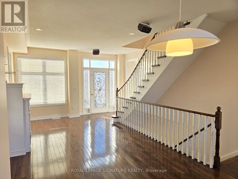 A spacious room with a staircase and a chandelier.