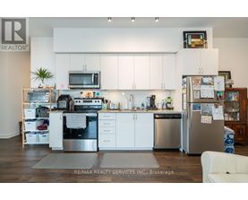 A kitchen with white cabinets and a refrigerator with a lot of papers attached to it.