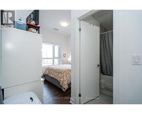A bedroom with a bed, a toilet, and a wardrobe.