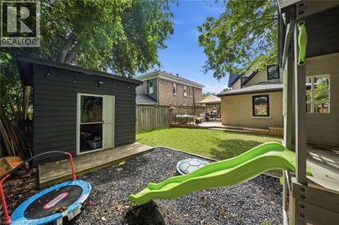 A backyard with a playground and a trampoline.