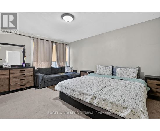 A bedroom with a large bed and a couch.